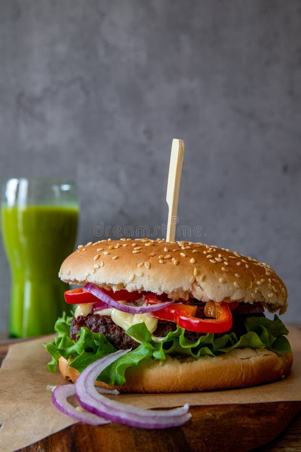 Frisch gemacht Hamburger auf der Platte auf der hölzern tisch a Grün, kopieren raum, vertikal.