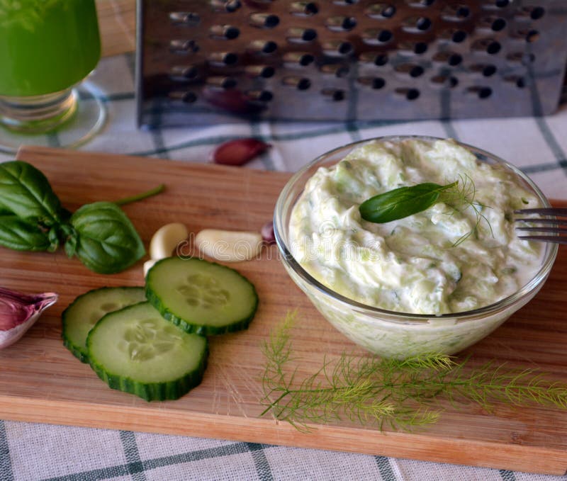 Freshly prepared tzatziki sauce on a glass bowl.