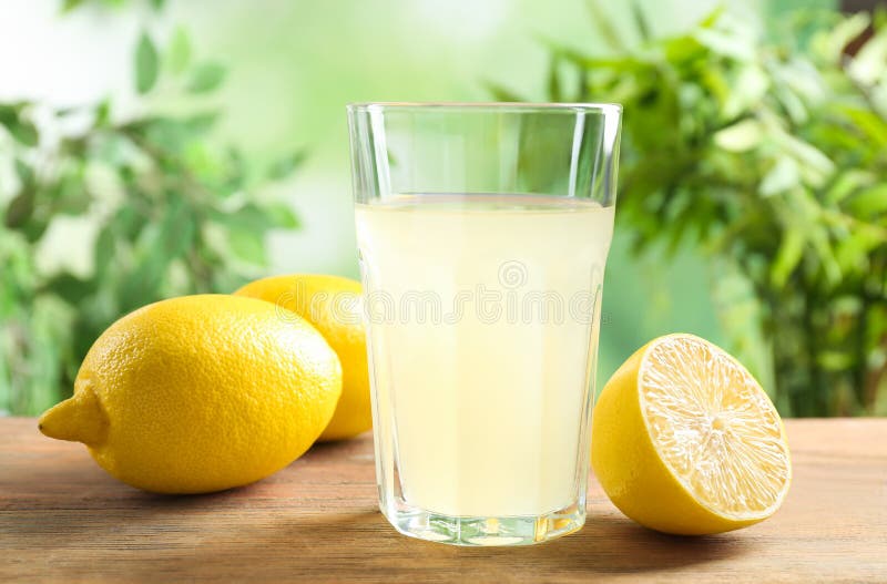 Fresco impreso limón jugo en vaso sobre el de madera.