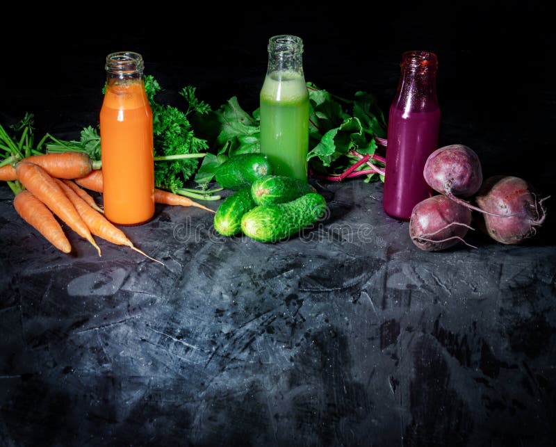 Freshly squeezed vegetable juice in bottles, useful vitamin cocktail. On dark background. Healthy eating and healthy organic food concept stock images Freshly squeezed vegetable juice in bottles, useful vitamin cocktail. On dark background. Healthy eating and healthy organic food concept stock images