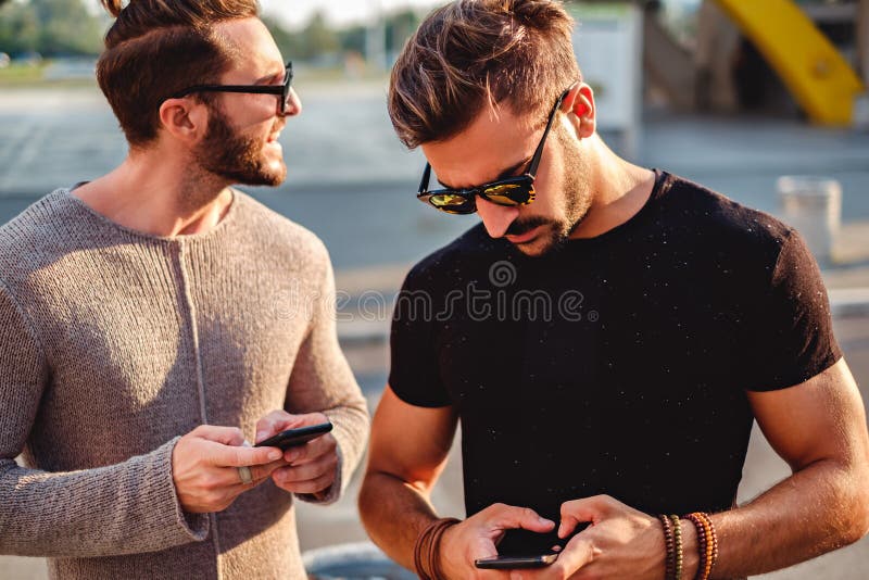 Freunde in der Straße, die Telefon nach dem Standort betrachtet stockbilder Freunde in der Straße, die Telefon nach dem Standort betrachtet stockbilder