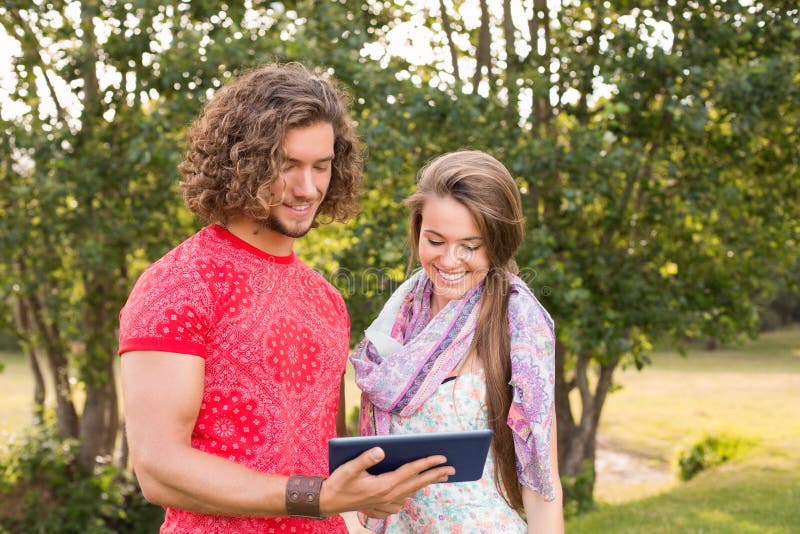 Freunde, die Tabletten-PC im Park verwenden stockbild Freunde, die Tabletten-PC im Park verwenden stockbild