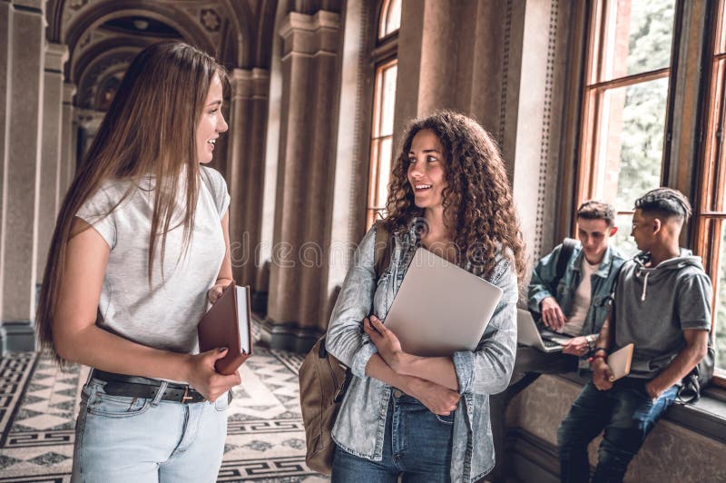 Freunde und Studienpartner! Gruppe Studenten, die zusammen stehen und auf der Hochschulhalle plaudern lizenzfreies stockbild Freunde und Studienpartner! Gruppe Studenten, die zusammen stehen und auf der Hochschulhalle plaudern lizenzfreies stockbild