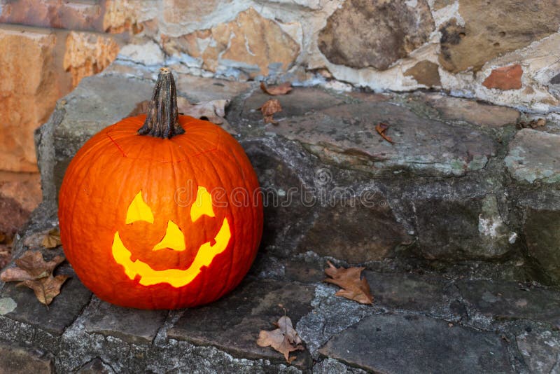 Freundliche Kinder einer beleuchtete Steckfassung-Olaterne zu einem Haus für die Trick-oder-Behandlung auf Halloween stockfotos