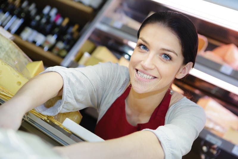 Freundliche Verkäuferin am Supermarkt lizenzfreies stockfoto Freundliche Verkäuferin am Supermarkt lizenzfreies stockfoto