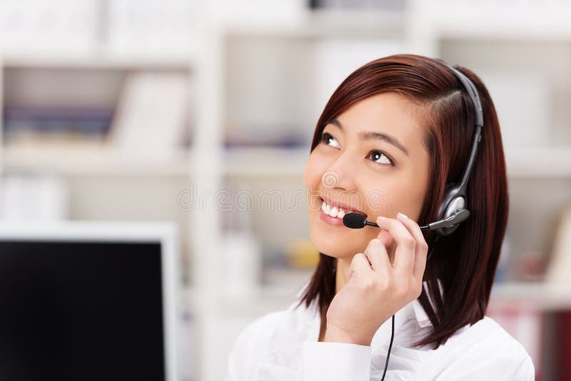 Freundlicher Call-Center-Betreiber, der an einem Telefon plaudert stockbild Freundlicher Call-Center-Betreiber, der an einem Telefon plaudert stockbild