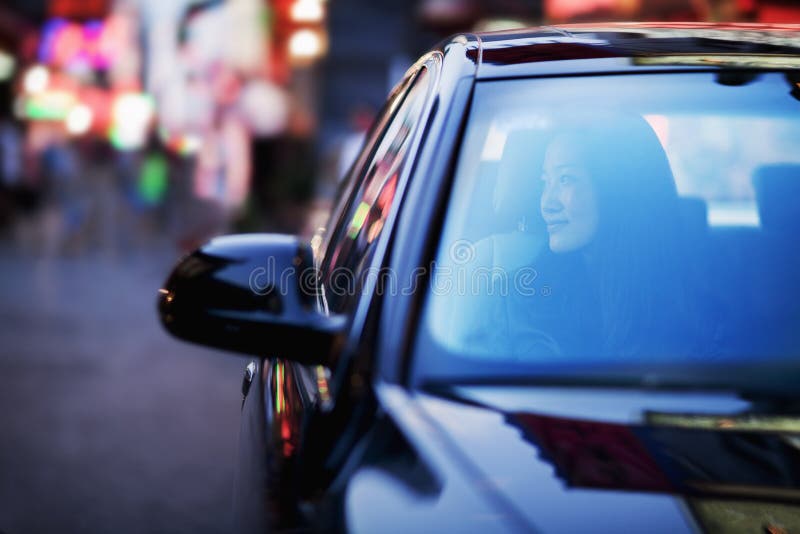 Fridfull kvinna som ser till och med bilfönster på stadsutelivet