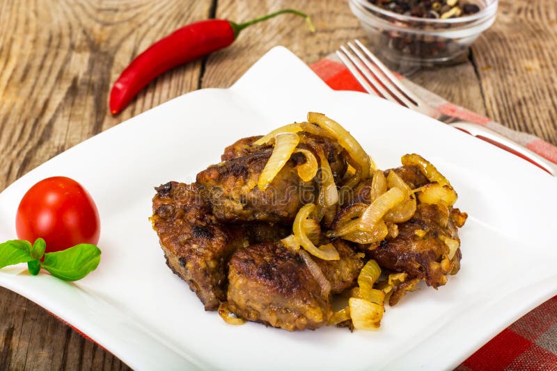 Fried beef liver with onions, curry and spices. Cuisine, olive. Stock