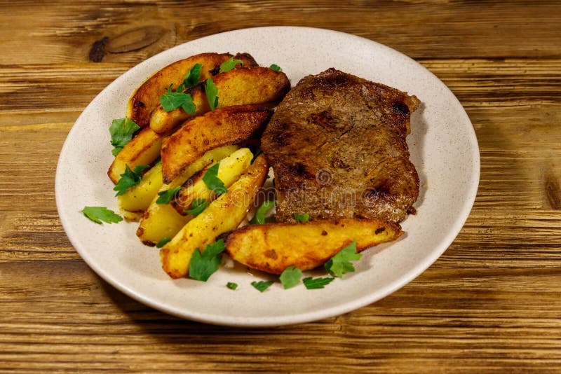 Fried Beef Steak with Potato Wedges on Wooden Table Stock Image - Image