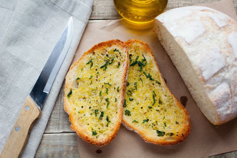 Fried Bread with Olive Oil, Garlic and Herbs on a Wooden Table. Rustic