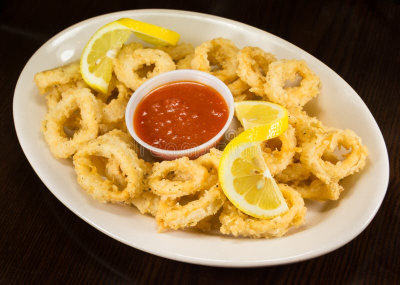 Fried Calamari with Red Tomato Sauce and Lemon on a Plate Stock Photo ...