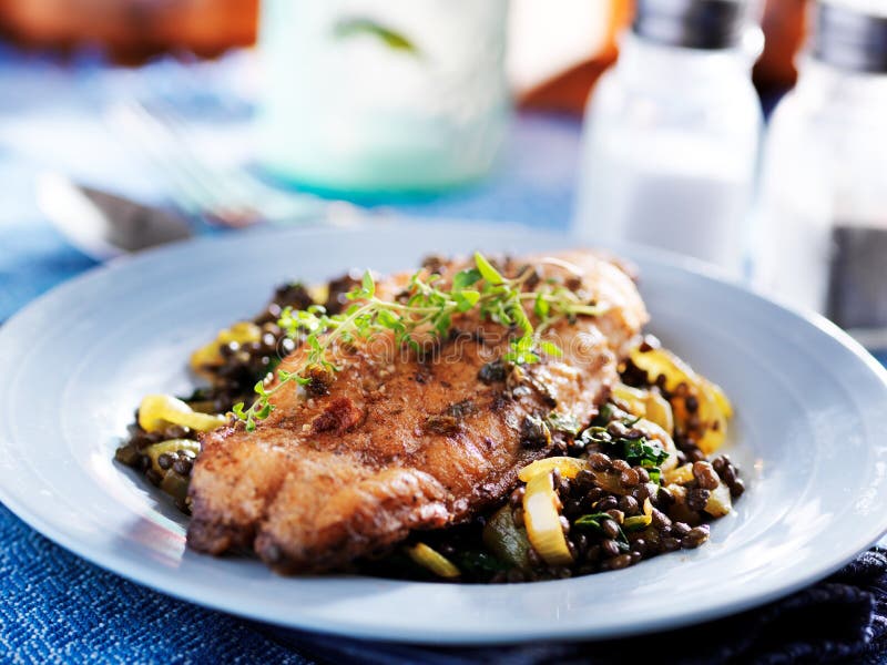 Fried Catfish on Black Lentils with Capers and Thyme Stock Photo