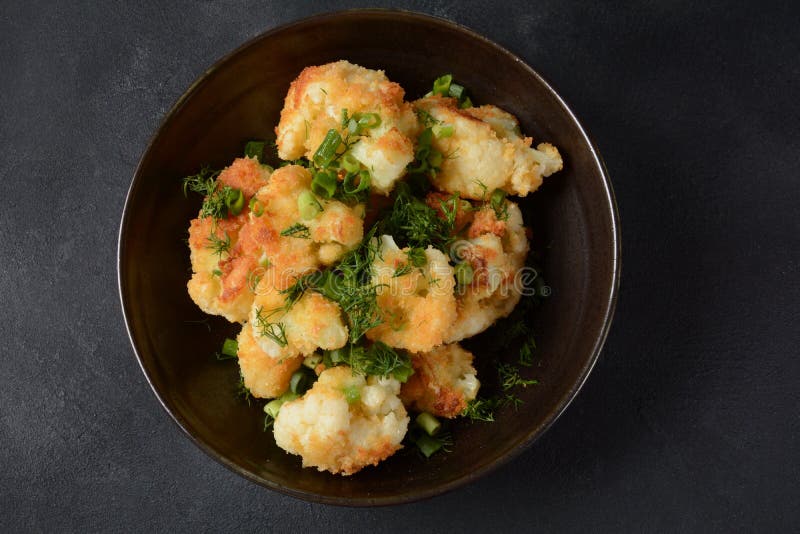 Fried Cauliflower Florets in Batter on a Black Plate. Stock Image