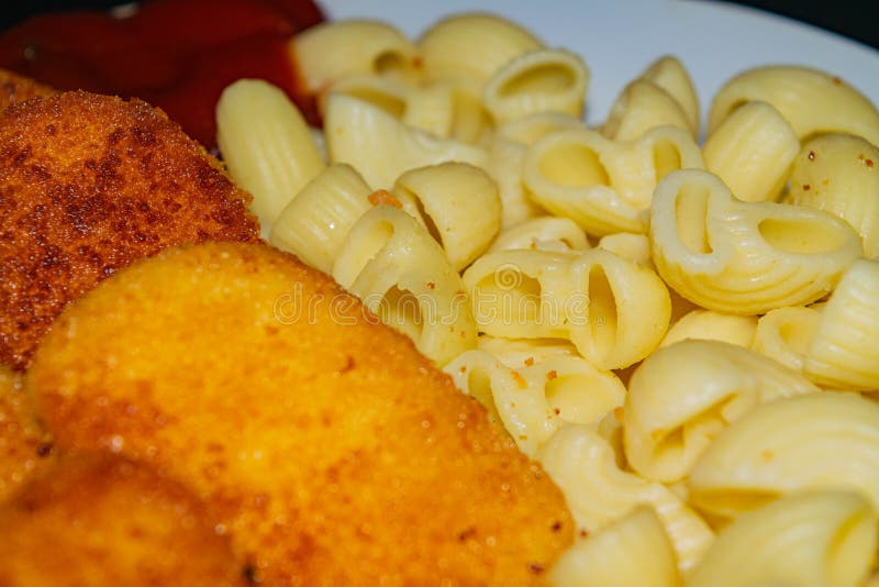 Fried Chicken Nuggets and Cooked Pasta on a Plate. Close Up Stock Image ...