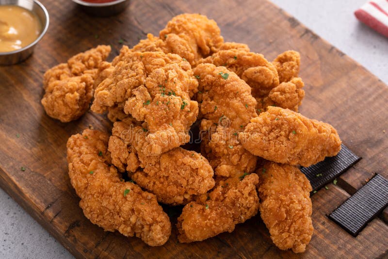 Fried Chicken Tenders or Strips with Sauces and Fries Stock Photo