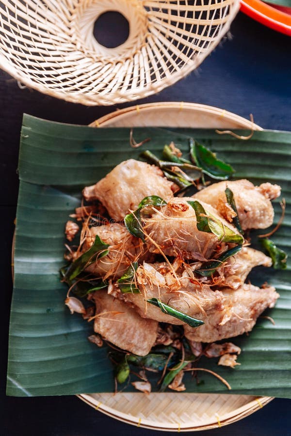 Fried chicken wings in Thai northeastern style with garlic and kaffir lime leaves served on banana leaf royalty free stock images Fried chicken wings in Thai northeastern style with garlic and kaffir lime leaves served on banana leaf royalty free stock images