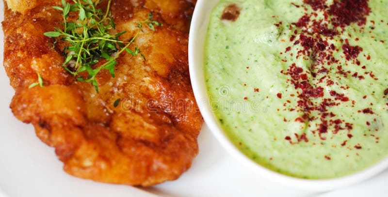 Fried cod fish in batter with cucumber and yoghurt dip, detail