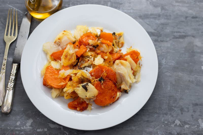 Fried cod fish with sweet potato on white dish on ceramic background