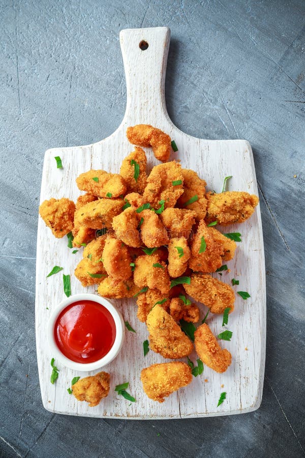 Fried Crispy Chicken Nuggets with Ketchup on White Board Stock Photo