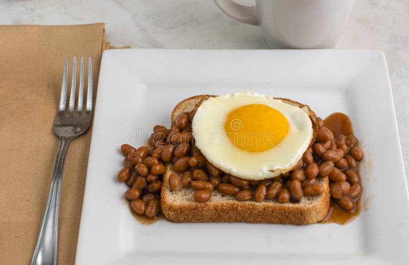 Fried egg and baked beans on wheat bread royalty free stock image