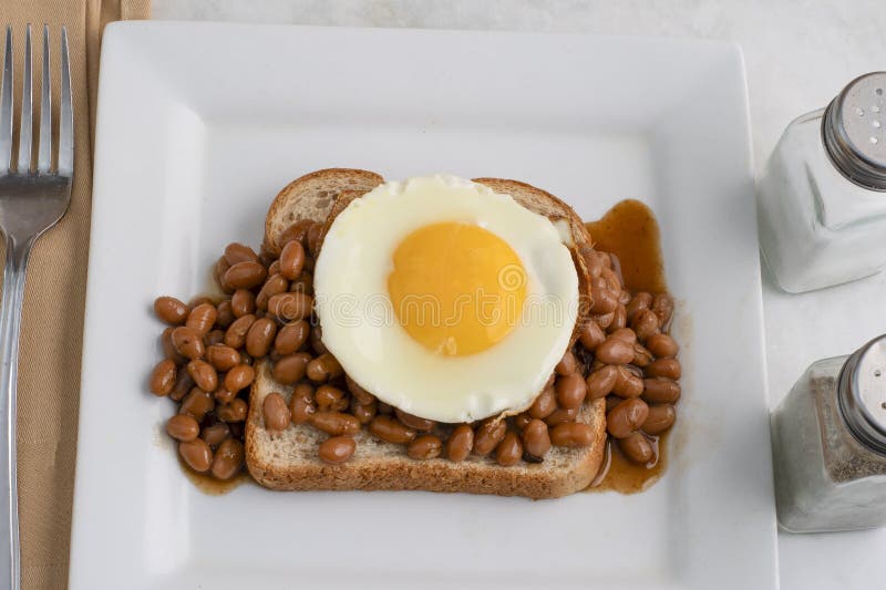 Fried egg and baked beans on wheat bread royalty free stock image