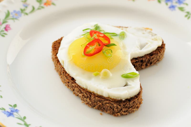 Fried Egg Heart Rye Sandwich with Scallion and Chili on White Pl Stock