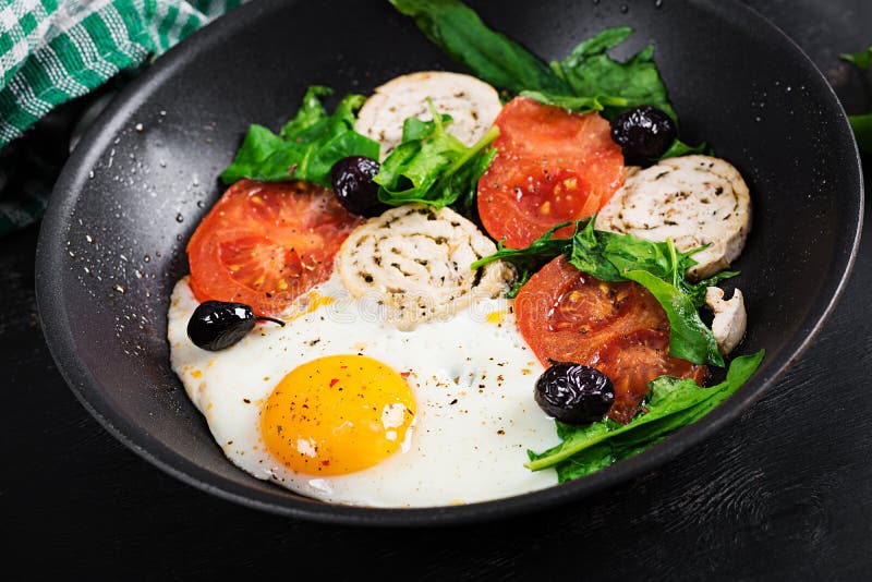 Fried Egg, Meat Roll, Black Olives, Tomatoes and Spinach. Stock Image