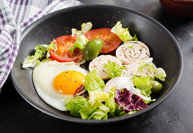 Fried Egg, Meat Roll, Olives and Tomatoes. Keto, Paleo Breakfast Stock