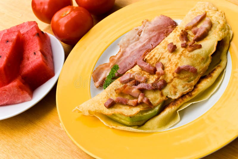 Fried eggs with bacon,melon and tomato