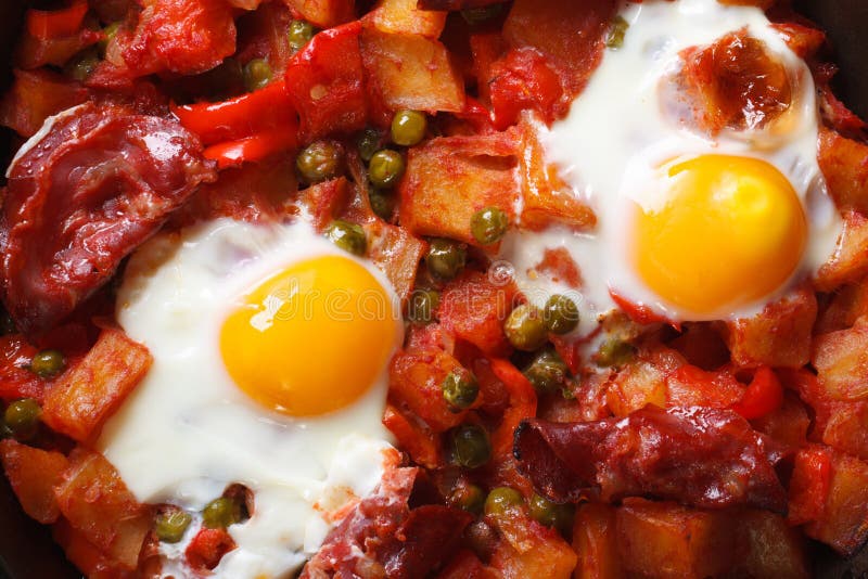Fried Eggs with Chorizo, Potatoes, Peas and Tomato Close Up Stock Photo