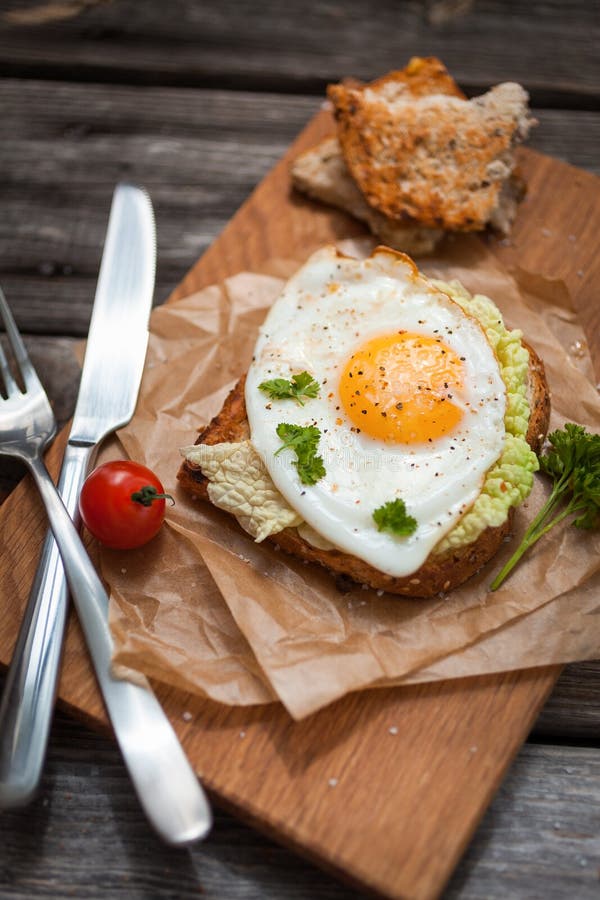 Fried Eggs and Fresh Bread with Cherry Tomatoes, Herbs and Spices for