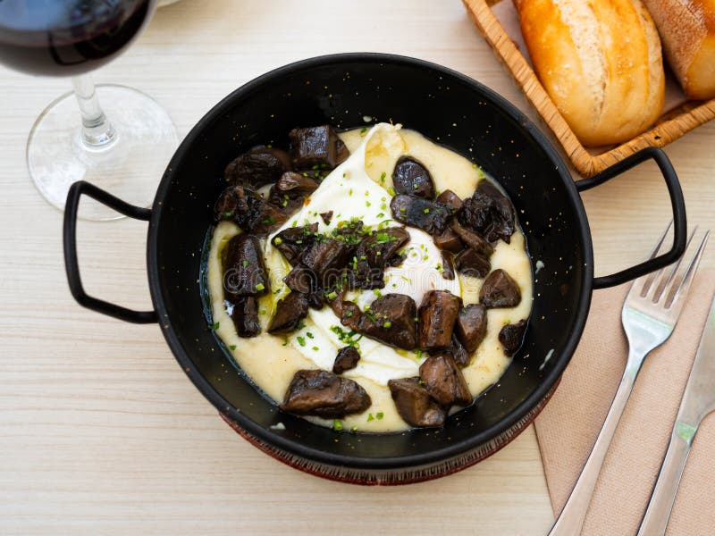 Fried Eggs on Mashed Potatoes Parmentier with Mushrooms Stock Photo