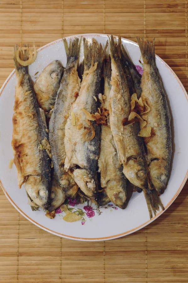 Fried fish Baltic herring lies on a plate on a bamboo napkin royalty free stock image Fried fish Baltic herring lies on a plate on a bamboo napkin royalty free stock image