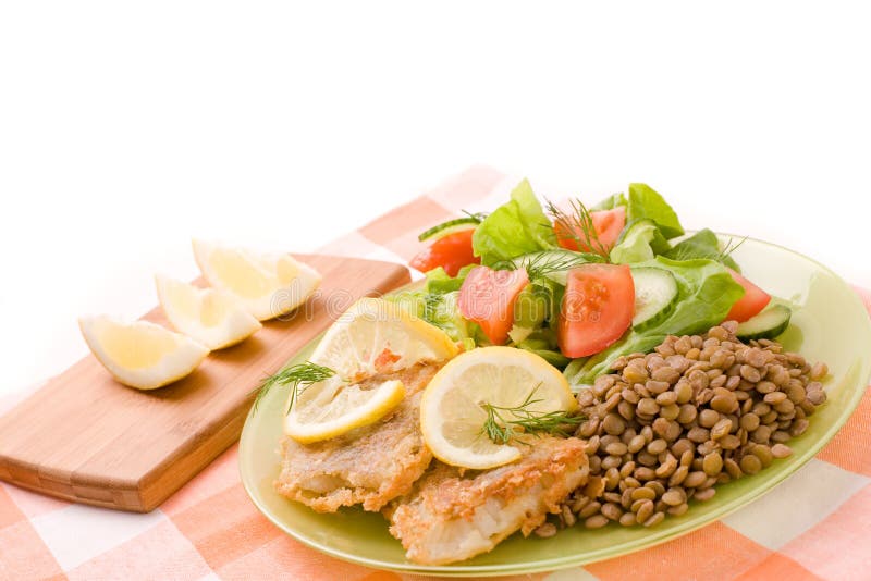 Fried fish fillets and fresh vegetables