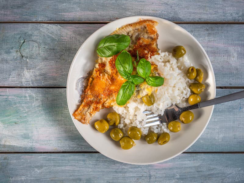 Fried Fish with Rice and Basil on a Light Plate Top View Stock Image