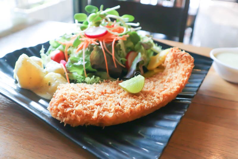 Fried Fish with Tomato Gravy and Salad or Fish and Chips Stock Photo