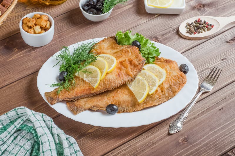 Fried Flounder with Lemon and Herbs on a White Plate on a Dark Wooden Background Stock Image