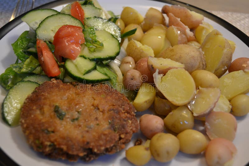 Fried meatloaf with young boil potatoes and cucumbers tomatoes salad. Fried meatloaf with young boil potatoes and cucumbers tomatoes salad