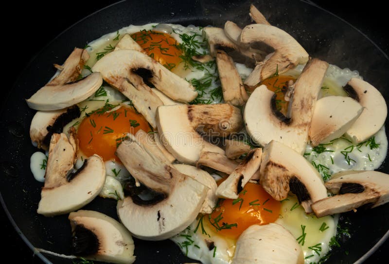 Fried Mushrooms and Eggs in a Pan. the Process of Cooking Breakfast