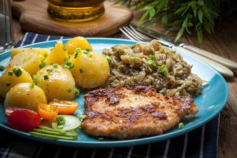 Fried Pork Chop, Baked Potatoes and Fried Young Cabbage. Stock Photo
