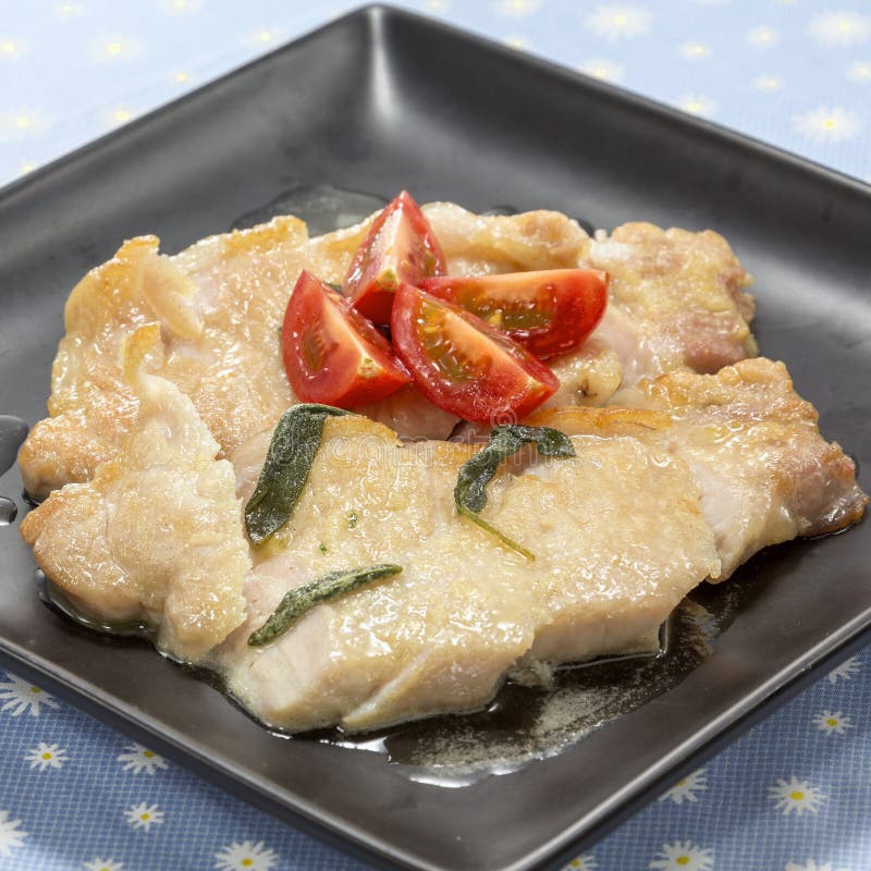 Fried Pork Cutlet with Fresh Tomatoes on Black Platter Stock Photo