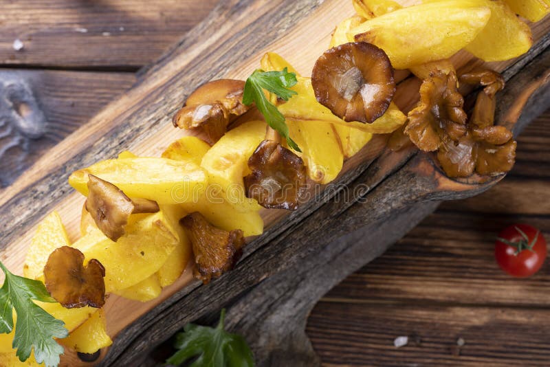Fried Potatoes with Chanterelles on Wooden Board on the Table Stock