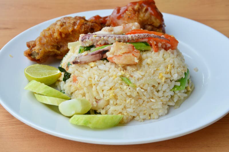 Fried Rice with Mixed Seafood and Crispy Chicken on Plate Stock Photo