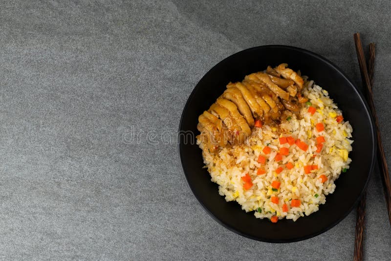 Fried rice with roast chicken and carrot in Korean style in black bowl on table royalty free stock photo Fried rice with roast chicken and carrot in Korean style in black bowl on table royalty free stock photo