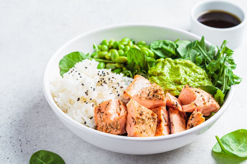 Fried salmon salad with rice, edamame and guacamole. Healthy diet recipe concept