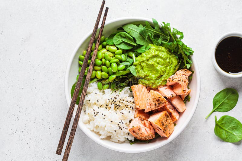 Fried salmon salad with rice, edamame and guacamole. Healthy diet recipe concept