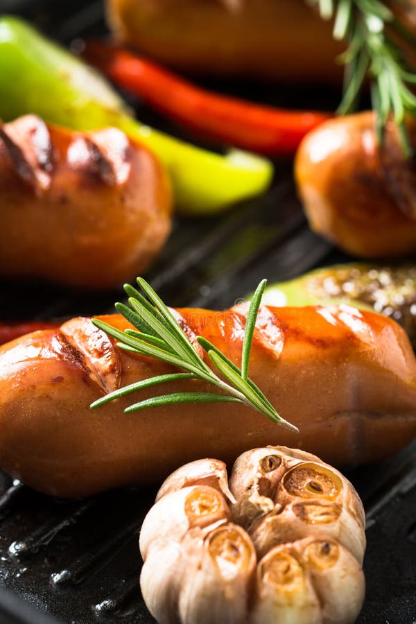 Fried Sausages with Vegetables in Grill Pan at Black Background Stock