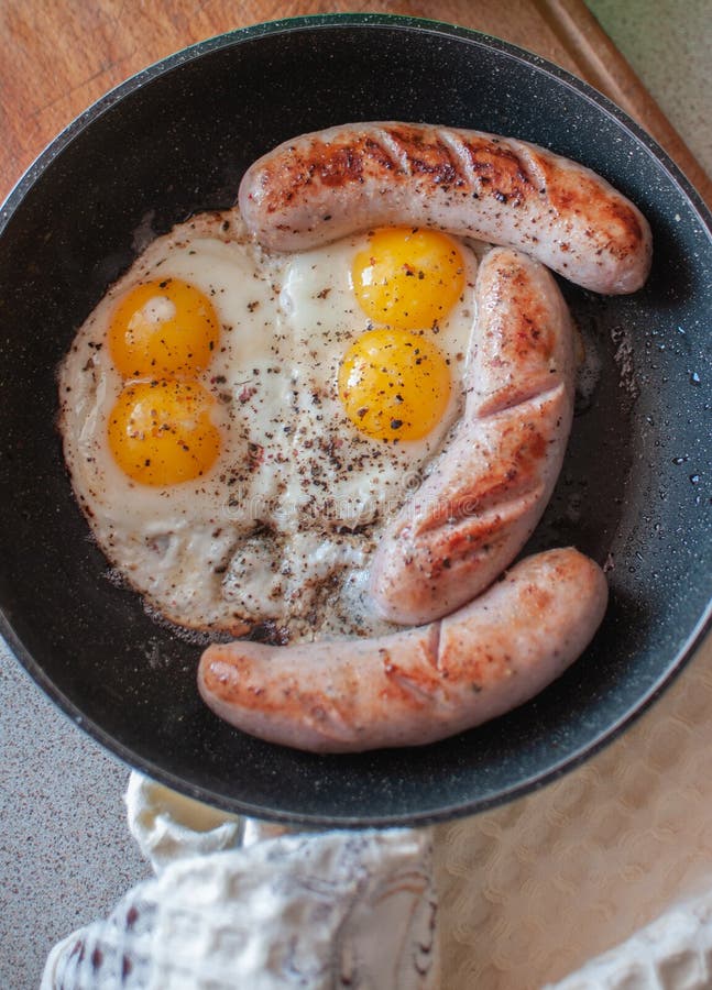 Fried Scrambled Eggs Fried Scrambled Eggs with Sausages in a Frying Pan ...