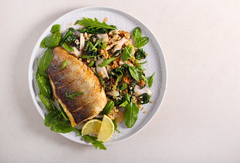 Fried sea bass fish and salad