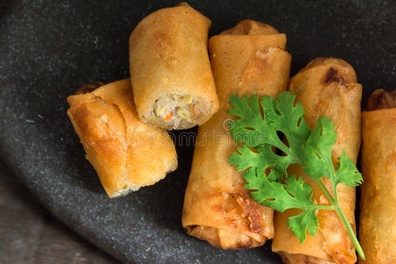 Fried Spring Rolls Stacked op zwarte leiplaat op houten bovenkant vi royalty-vrije stock afbeelding Fried Spring Rolls Stacked op zwarte leiplaat op houten bovenkant vi royalty-vrije stock afbeelding